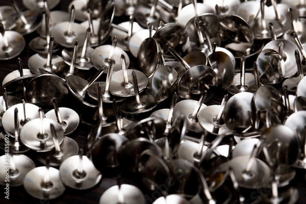 Fototapeta Abstract background in the form of stationery metal buttons with semicircular hats closeup.