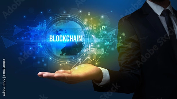 Fototapeta Elegant hand holding BLOCKCHAIN inscription, digital technology concept