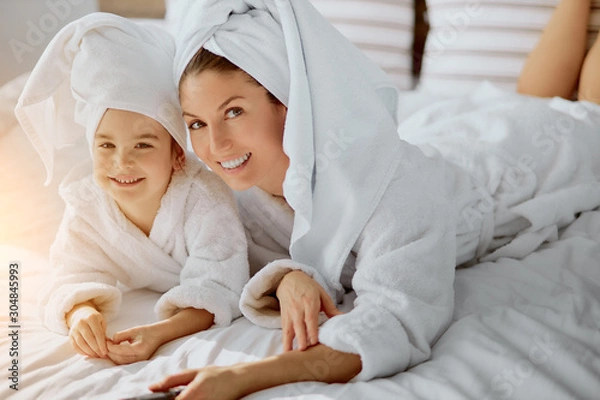 Fototapeta top view on caucasian mother and child looking at camera, wearing towel and bathrobe after bath shower, happy family concept