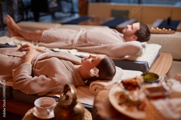 Fototapeta Young caucasian husband and wide take pleasure, take rest together in spa center, relax and rest of whole body