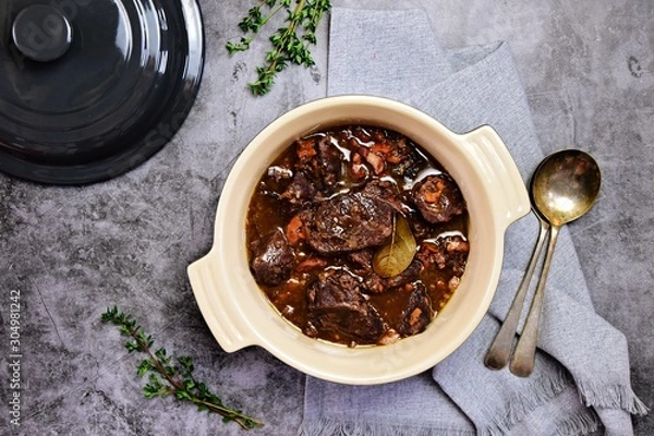 Fototapeta Beef bourguignon in the pot on the grey background, top view