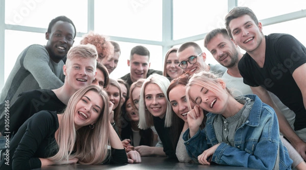 Fototapeta large group of cheerful friends sitting at the table