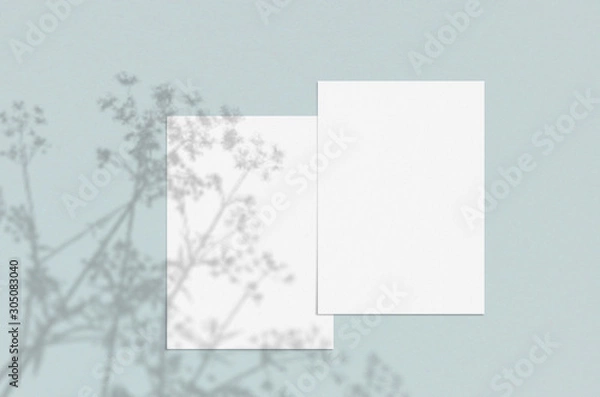 Fototapeta Blank white vertical paper sheet 5x7 inches with shadow overlay. Modern and stylish greeting card or wedding invitation mock up.