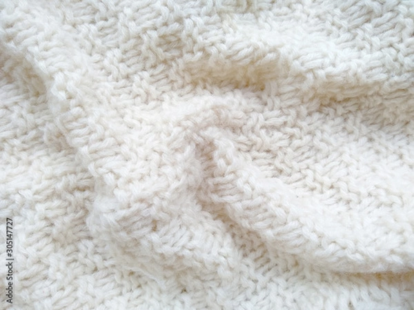 Fototapeta Background of wool yarn for yarn frame. White knitting yarn for handicrafts background. Knitted clothes from wool yarn.