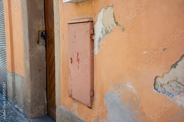 Fototapeta Electric panel door on the wall of an old house