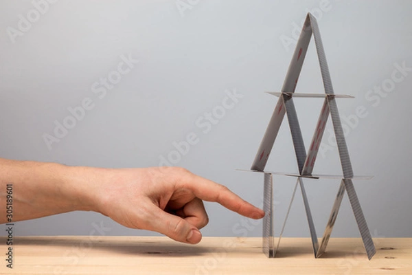 Fototapeta Hand breaks the house of cards