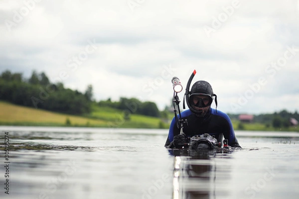 Obraz A scuba diver in a wet suit prepares