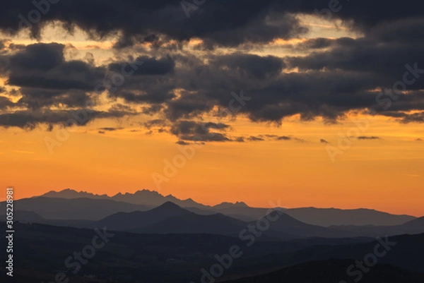 Fototapeta A mountain silhouette in the evening on a background of red sky