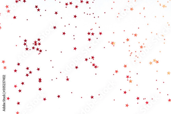 Fototapeta Red stars glitter confetti on white background. Festive backdrop.