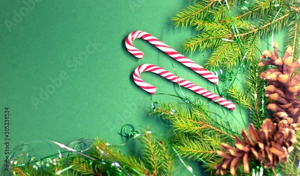 Obraz  Christmas card with spruce and holiday decorations, sweets, on a green background. Christmas template for banner, ticket, brochure, card, invitation, poster, etc. Place for text.