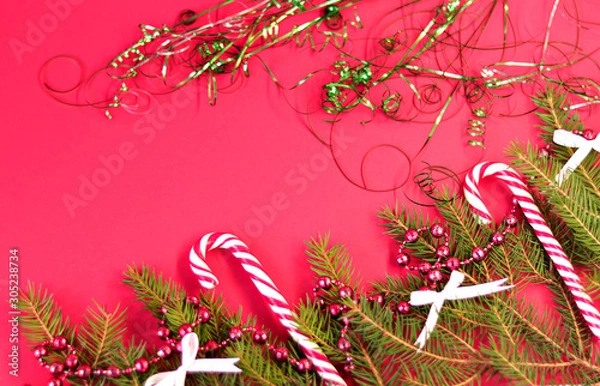 Obraz Christmas card with spruce and holiday decorations, sweets, on a red background. Christmas template for banner, ticket, brochure, card, invitation, poster, etc. Place for text.