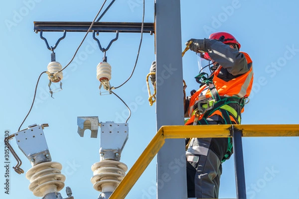 Obraz Working electrician working with electrical equipment