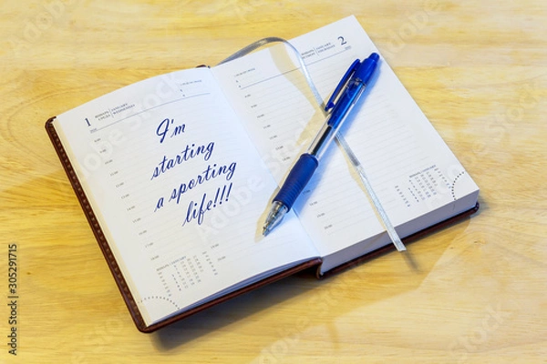 Fototapeta The diary is on the table. The diary is open on the first of January page. The page reads: "I'm starting a sporting life!!!".