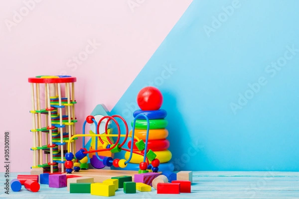 Fototapeta Colorful kids toys frame on wooden background. Top view. Flat lay. Copy space for text