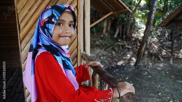 Obraz Portrait of young girl wearing traditional dress 'baju kurung' with hijab. Selected focus. Image contain certain grain or noise and soft focus when view at full resolution.