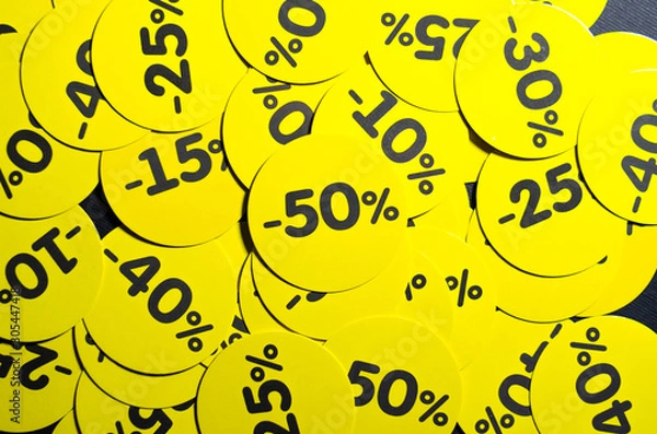 Fototapeta Yellow round stickers with discounts of 10 to 50 percent. Sell-out. Discounts on a black background. Black Friday. Price fall. Posters. Macro discounts.