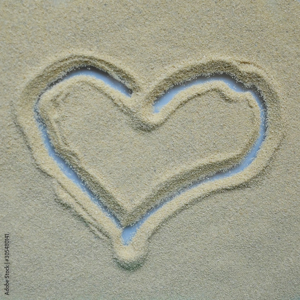 Fototapeta The heart is painted on a sandy surface. Concept, falling in love, Declaration of love.
