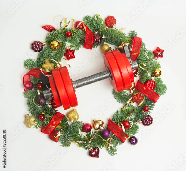 Obraz Christmas or New Year on a white background. Composition with dumbbells, gift, red and gold glass balls, fir tree branches for healthy lifestyle and sport