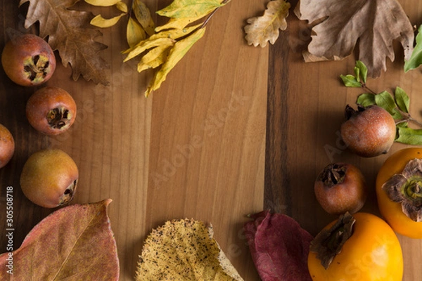 Fototapeta paradise palm and autumn leaves on the wooden background.