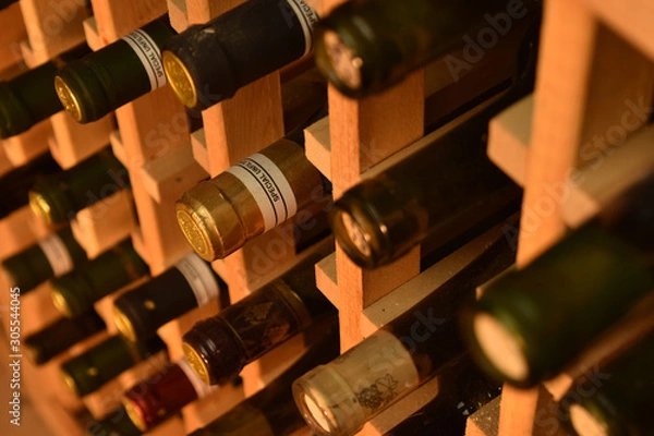 Fototapeta wine bottle necks sticking out of front of wooden wine rack