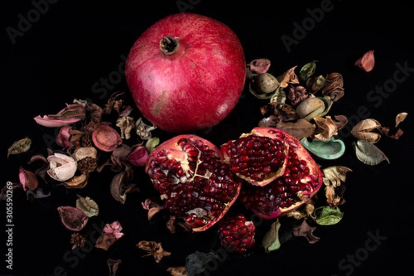Fototapeta ripe pomegranate rustic style on black isolated background still life