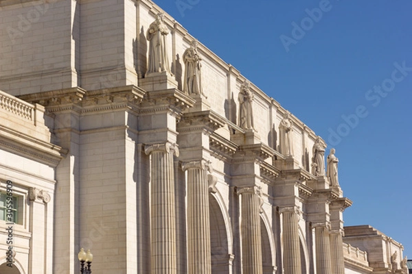 Fototapeta Union Station building facade in Washington DC, USA. Monumental building with statues under a clear blue sky.