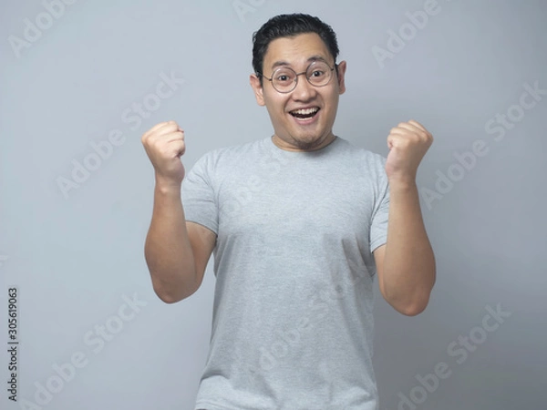 Fototapeta Funny Asian Man Shows Surprised Happy Expression