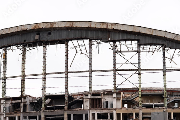 Fototapeta Demolition of the arena. Old metal frame of the building, destroyed walls.