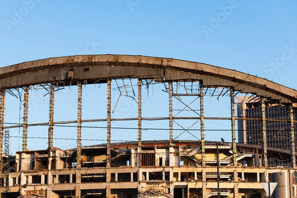 Fototapeta Demolition of the arena. Old metal frame of the building, destroyed walls.
