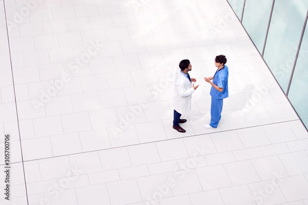 Fototapeta Overhead View Of Male Medical Staff Having Informal Meeting In Lobby Of Modern Hospital Building