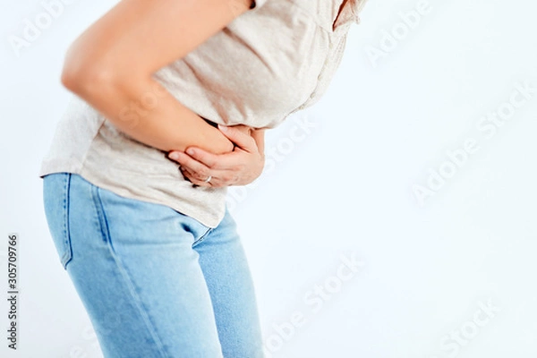 Obraz Woman with stomach/ hip issues / problems on the white background.
