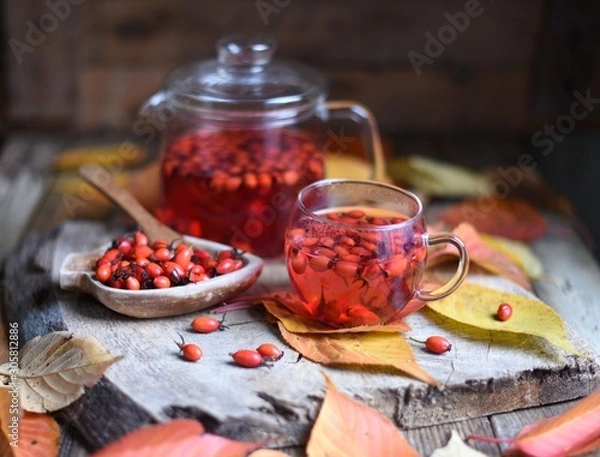 Fototapeta Rosehip tea in a glass on a wooden table