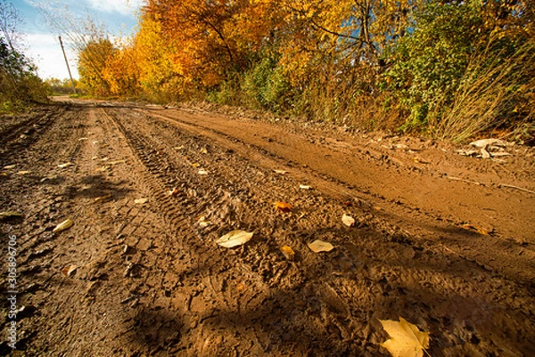 Fototapeta Landscape with impassable autumn road with tire tracks