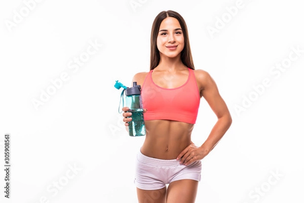 Fototapeta Sporty muscular woman drinking water against white background