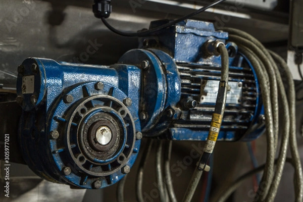 Obraz Close up image of blue mechanical pump or drive type industrial metal piece of heavy duty equipment. with metal hoses and built with clean and dirty rusty nuts and bearings 