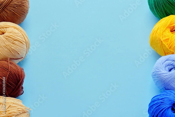 Fototapeta Mock-up made with bright color yarn clews on the blue background. Concept of amigurumi toy making, handicraft, knitting, hobbie. Can be used for posters