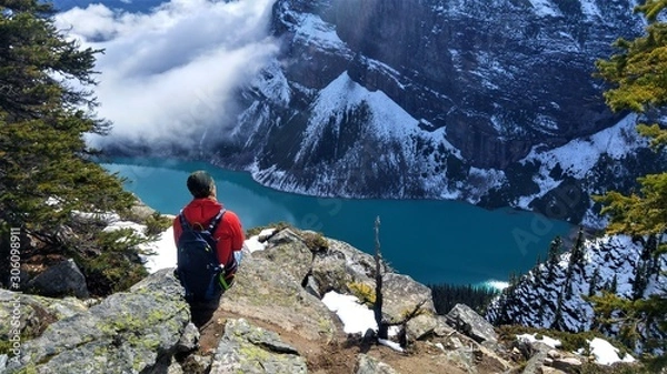 Obraz Man sitting on a rock looking above the Lake Louise. Nice viewpoint in Banff Nationalpark, Canda