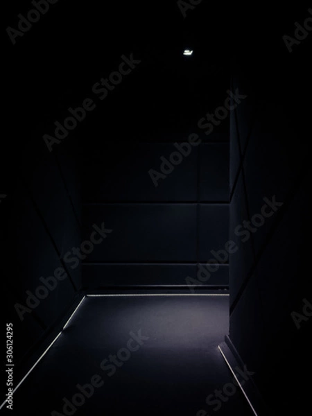 Fototapeta Corner of a dimmed empty corridor of a building