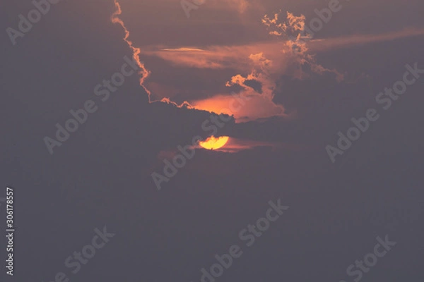 Fototapeta Beautiful sun. The sun is hiding behind the clouds. Perspective.
