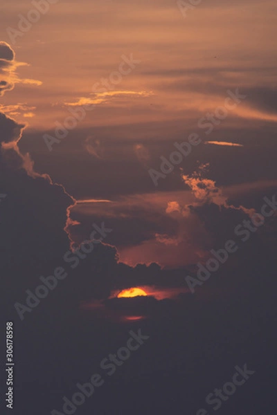 Fototapeta Beautiful sun. The sun is hiding behind the clouds. Perspective.