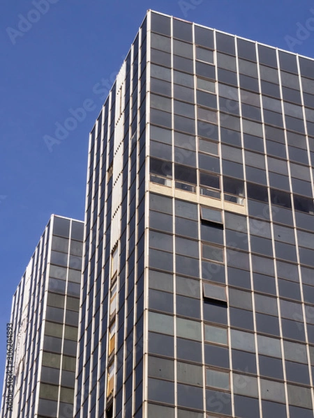 Fototapeta Brussels, Belgium, 10/07/2019 Old unkept sky scraper poorly maintained European office building with blue skies and rusty, dirty windows in the main business district of Brussels