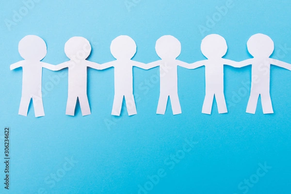 Obraz White paper people holding hands. Blue background