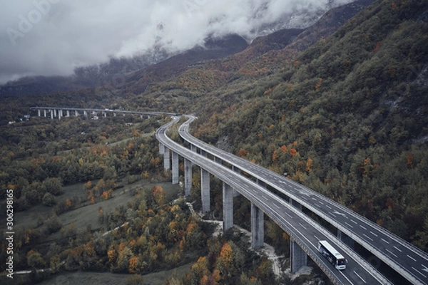 Fototapeta High autumn alpine speed road in Italia. Aerial view from above with clouds on the background