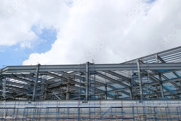 Obraz The structure of building with blue sky and cloud as a background, Steel construction in large construction site, Space for text in template