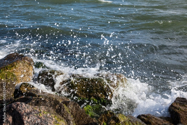 Fototapeta Waves breaking onto a stony seashore.