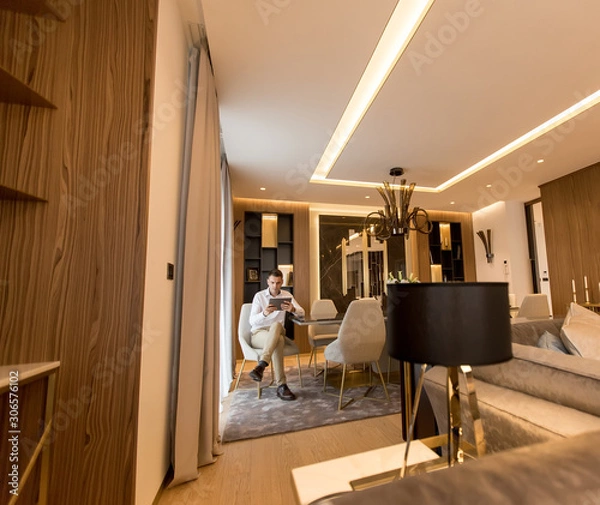 Fototapeta Handsome young man using digital tablet at luxury apartment