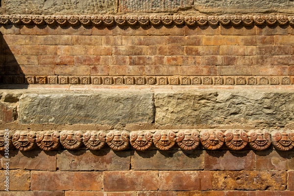 Fototapeta Graceful ancient stone carving. Brown stone texture. Wall of an old Hindu temple at Durbar Square in Kathmandu, Nepal