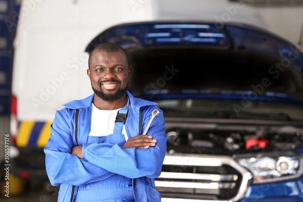 Fototapeta African-American mechanic in car service center