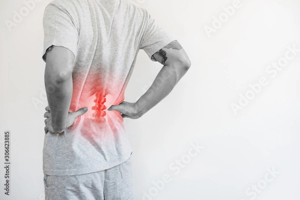 Fototapeta Office syndrome, Backache and Lower Back Pain Concept. a man touching his lower back at pain point