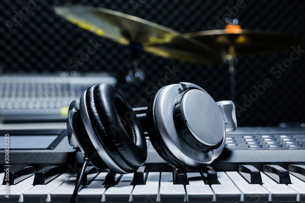 Fototapeta Piano keyboard with headphones for music, Headphones on piano keyboard, close up,headphones on electric piano background by the music instruments background.